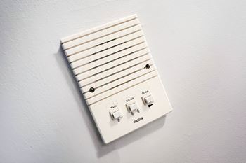 A white wall-mounted device with multiple buttons and switches.
